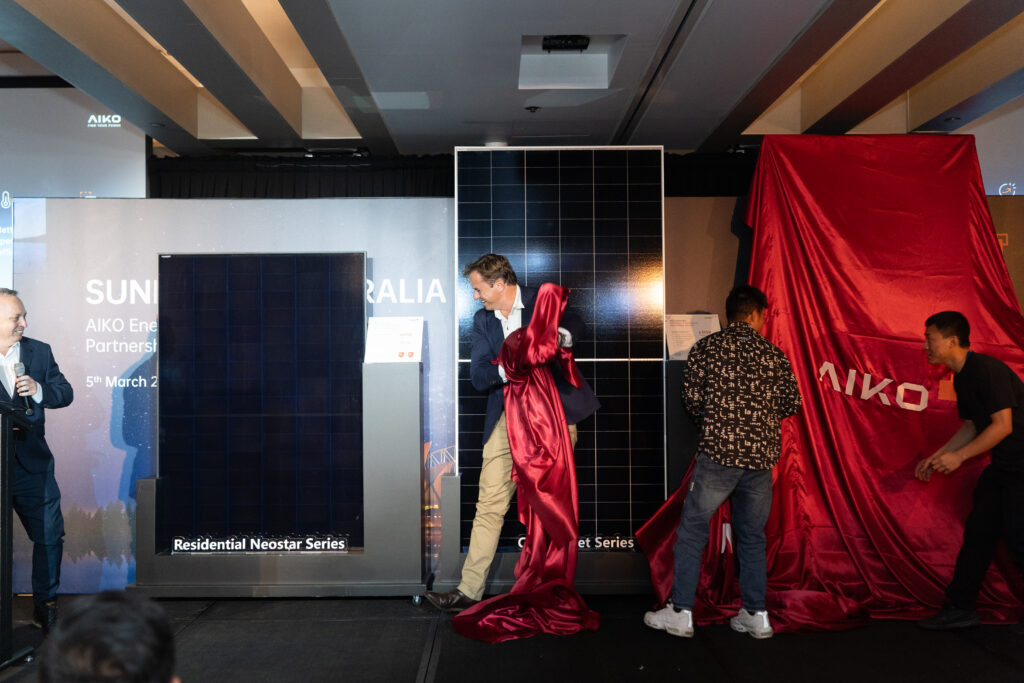 Derek McKercher unveiling the Aiko Neostar ABC n-type residential solar panel at the Aiko launch event, Cockle Bay, Sydney during Ross Crawford's key note presentation.